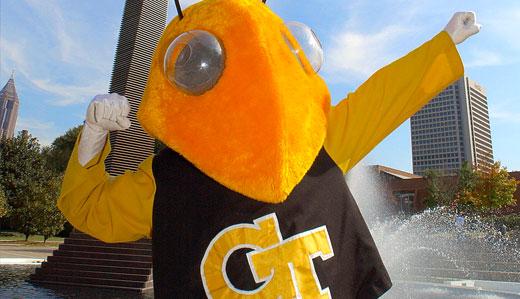 Buzz, Georgia Tech’s mascot, poses for the camera with the Atlanta skyline and Campanile in the background.