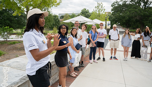 A Georgia Tech campus tour guide speaks to a tour group outside of Tech’s student center.