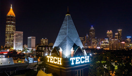 A view of Tech Tower at night among the Atlanta skyline.