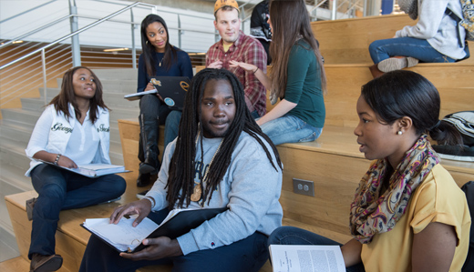 Students sit on wooden steps in the Clough Undergraduate Learning Commons on campus in Atlanta, Georgia.